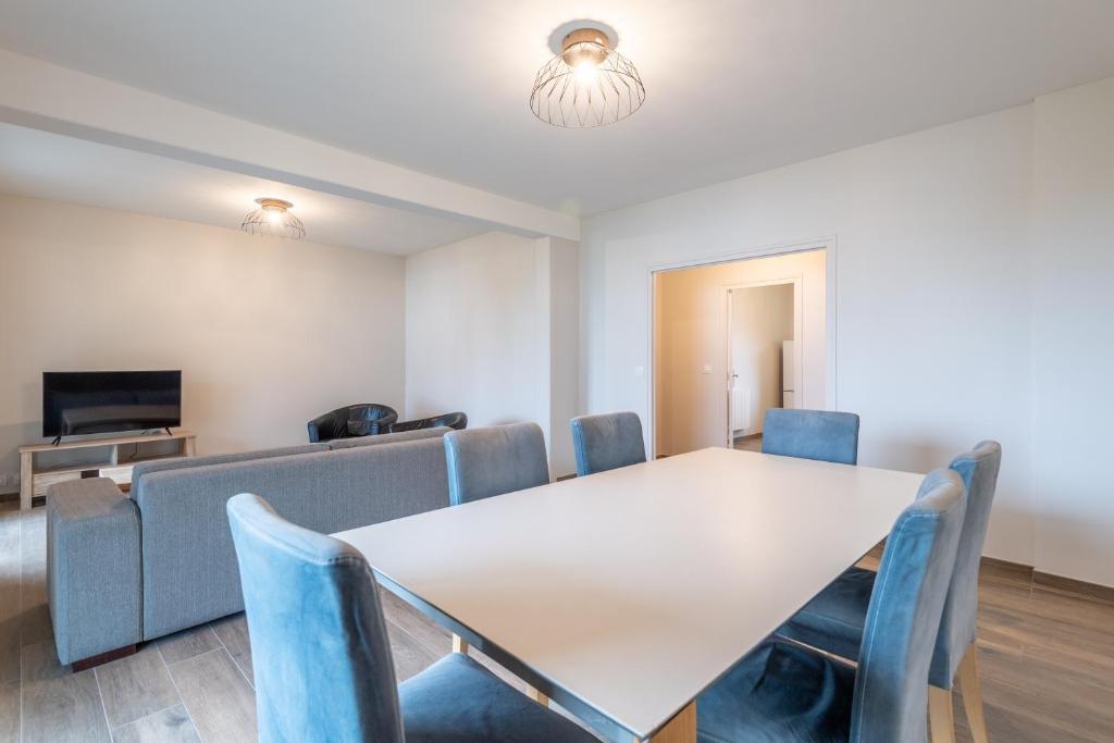 una sala de conferencias con una mesa blanca y sillas azules en Appartement de standing, en Albertville