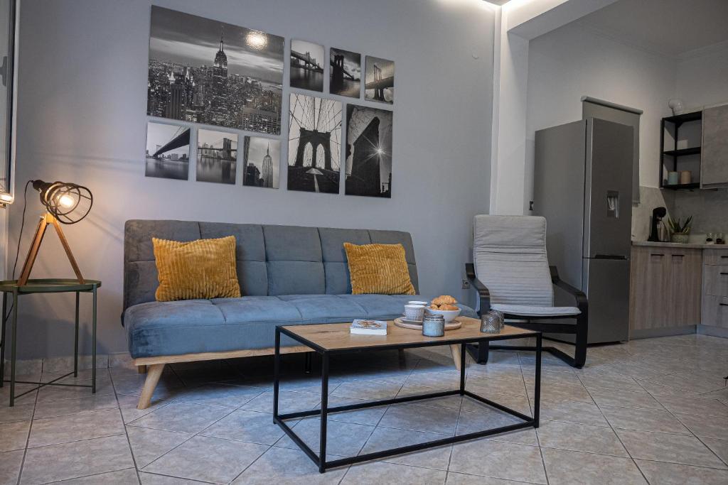 un soggiorno con divano blu e tavolo di Thalia apartments a Kalamáta