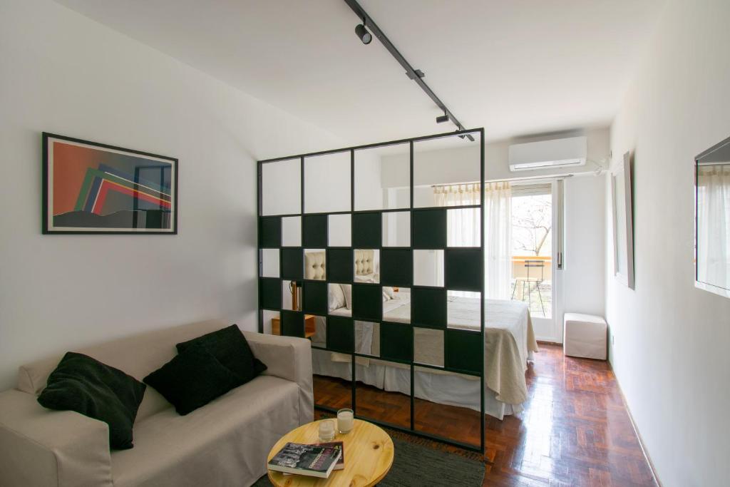 ein Wohnzimmer mit einem Sofa und einem Bett in der Unterkunft Franca Estadías Temporarias in Rosario