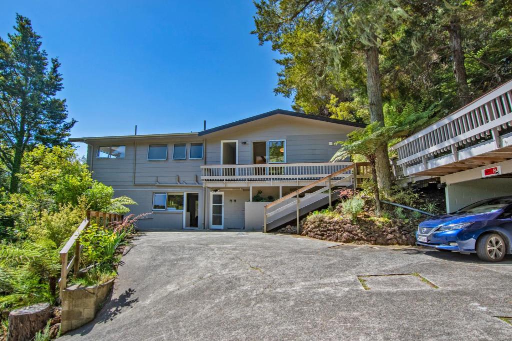 a house with a car parked in the driveway at Camellia with WiFi - Paihia Unit in Paihia