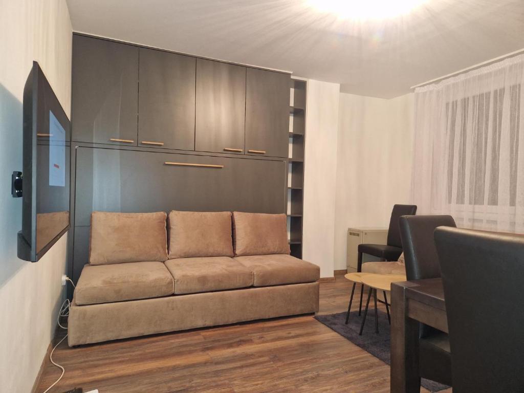a living room with a couch and a table at Extra studio apartment Sarajevo in Sarajevo