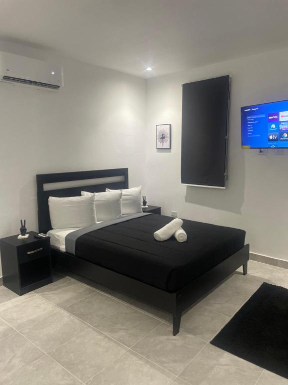 - une chambre avec un grand lit noir et une télévision à écran plat dans l'établissement Perfect suite #1 #3, à San Juan