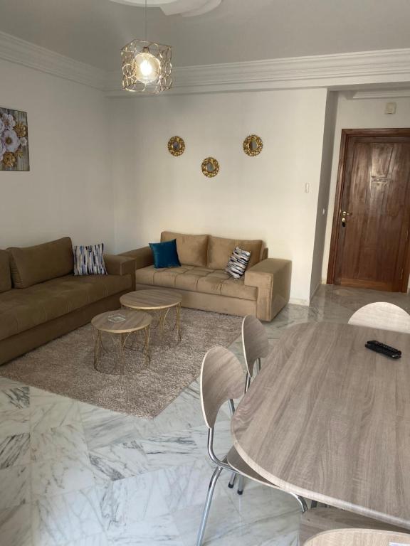 sala de estar con sofá y mesa en Magnifique Appartement Vue Mer en Nabeul