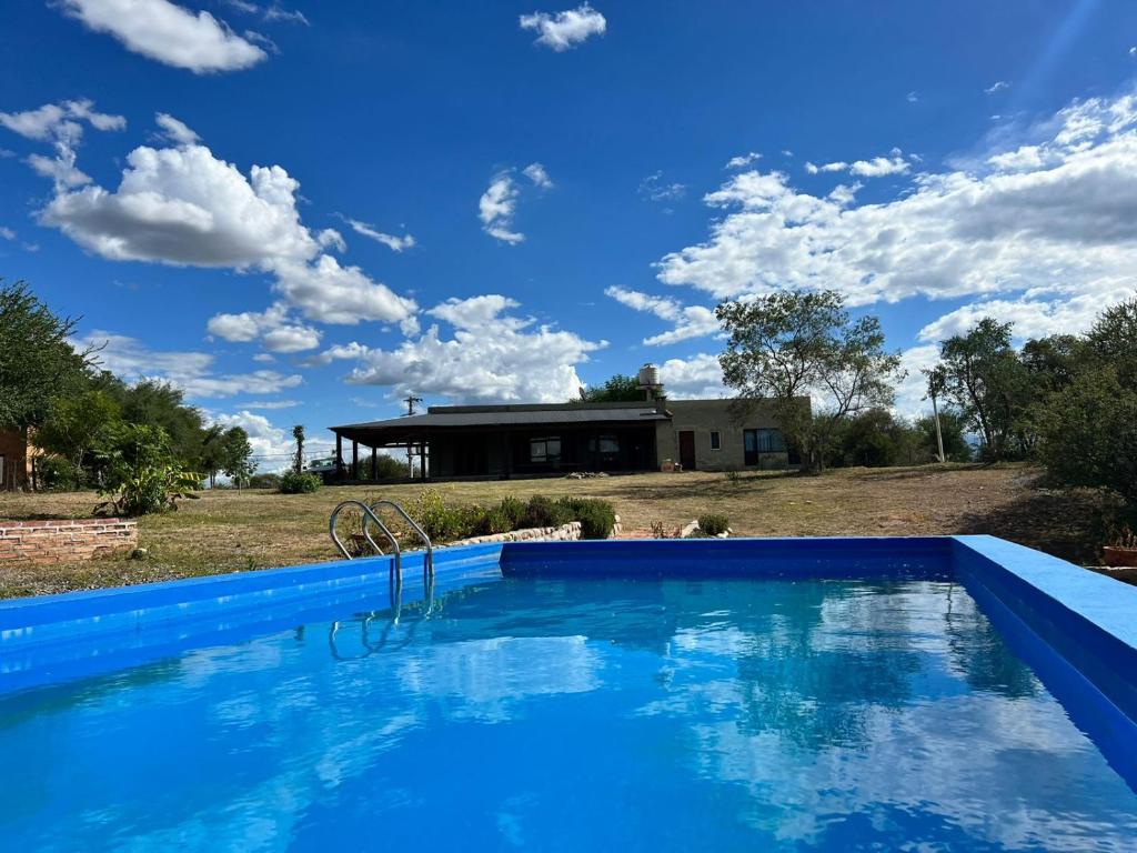 a blue swimming pool in front of a house at Punta Sur - Dique Cabra Corral in Coronel Moldes