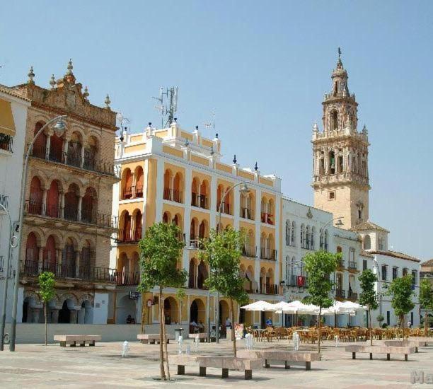 a large building with benches in front of it at APARTAMENTOS TRES SOLES in Écija