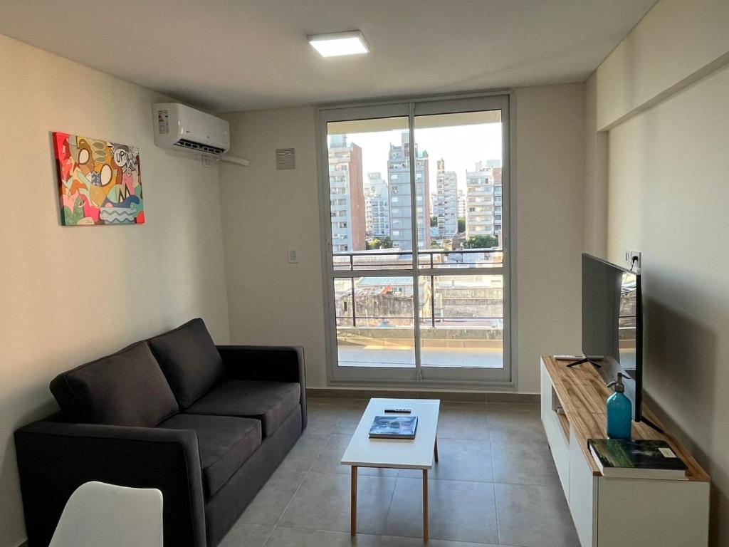 sala de estar con sofá y ventana grande en Nuevo, Bellísimo, Confort y muy amplio - 2 Dormitorios, uno en Suite - 2 baños y Pileta !! en Rosario