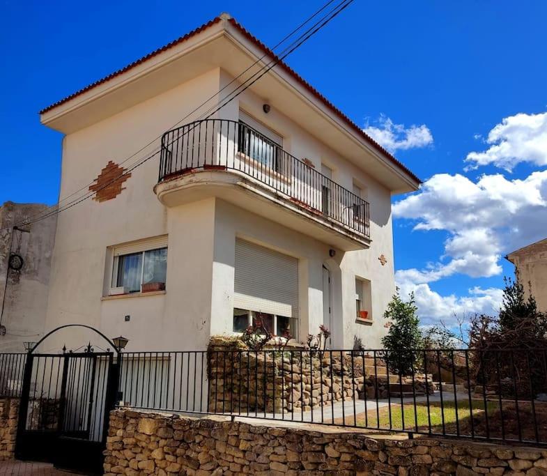 a white house with a fence in front of it at La casa de la Plaza - WIFI - Barbacoa - Chimenea in Cirueña