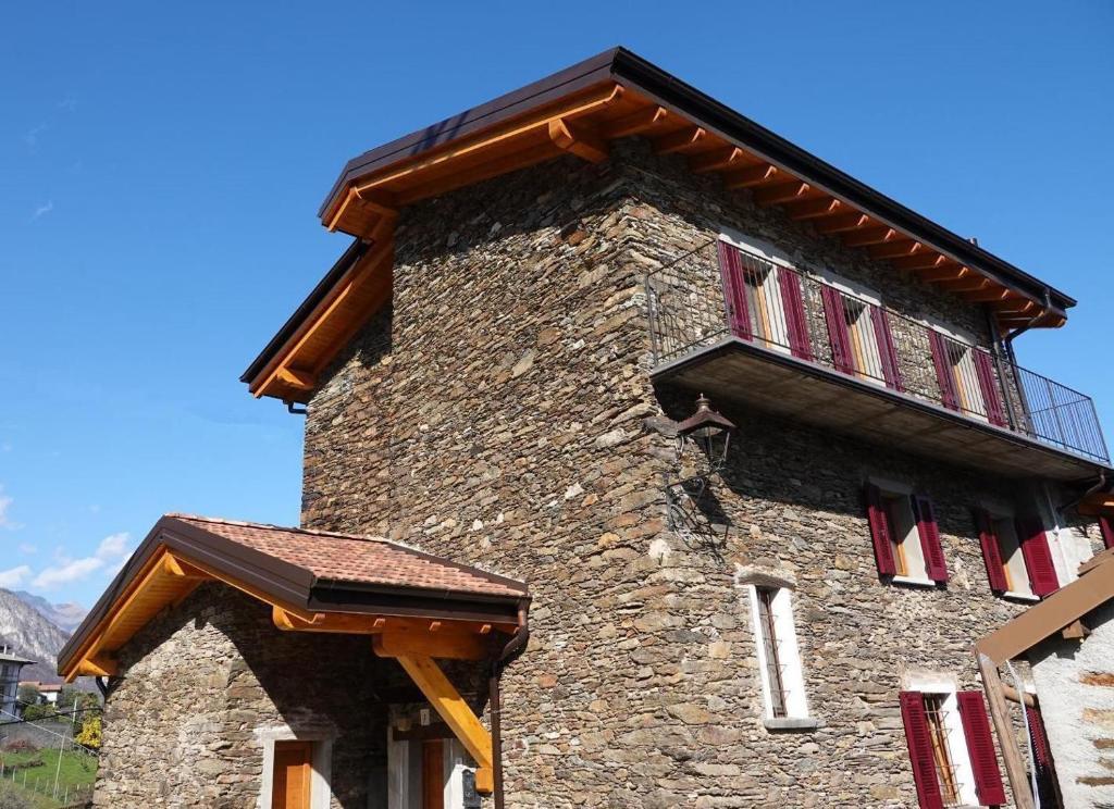 un edificio de piedra con balcón en la parte superior. en Casale Bella.Vista, en Pianello Del Lario