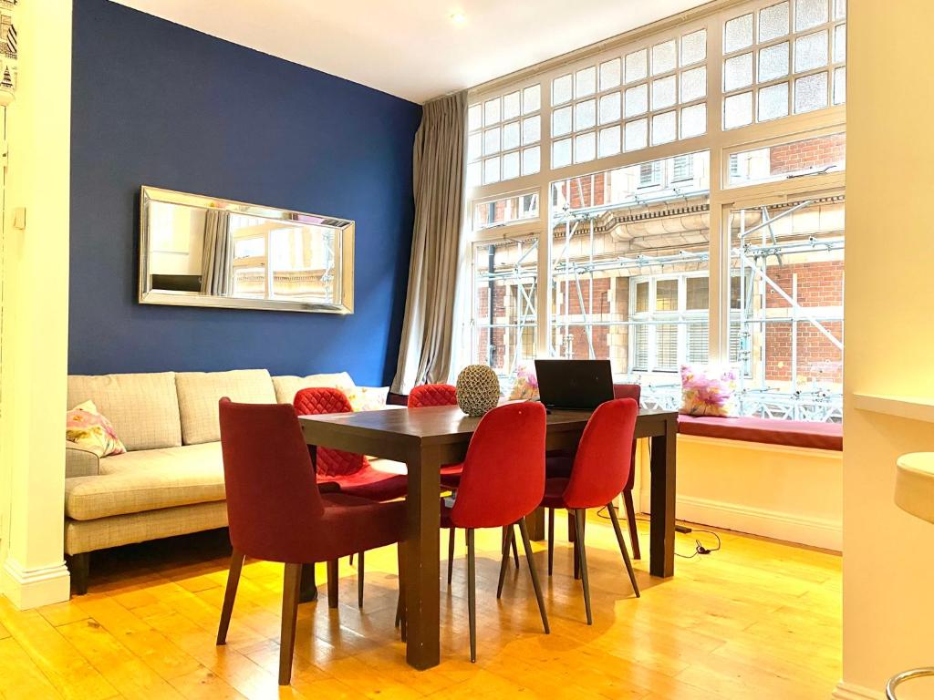 a dining room with a table and chairs and a couch at Sight Flats - SF02 - One Bedroom in London