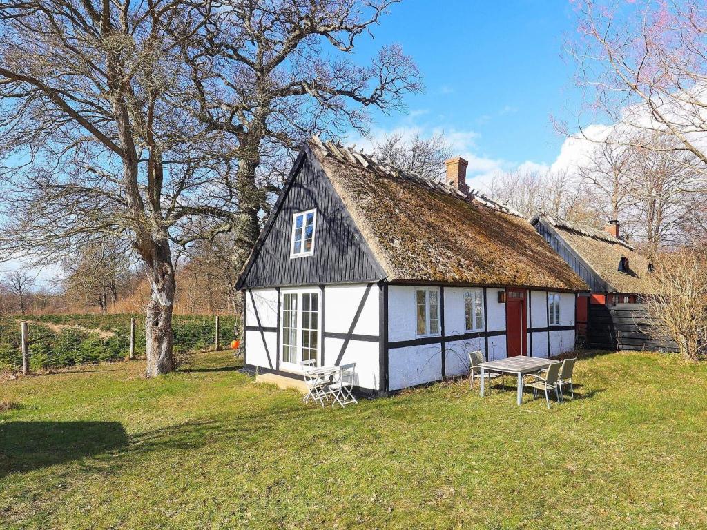 una casa blanca y negra con una mesa de picnic delante en Holiday home Præstø V, en Præstø