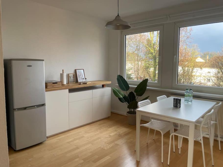 Il comprend une cuisine équipée d'une table blanche et d'un réfrigérateur blanc. dans l'établissement Ruhig und zentral wohnen! MA3R, à Essen