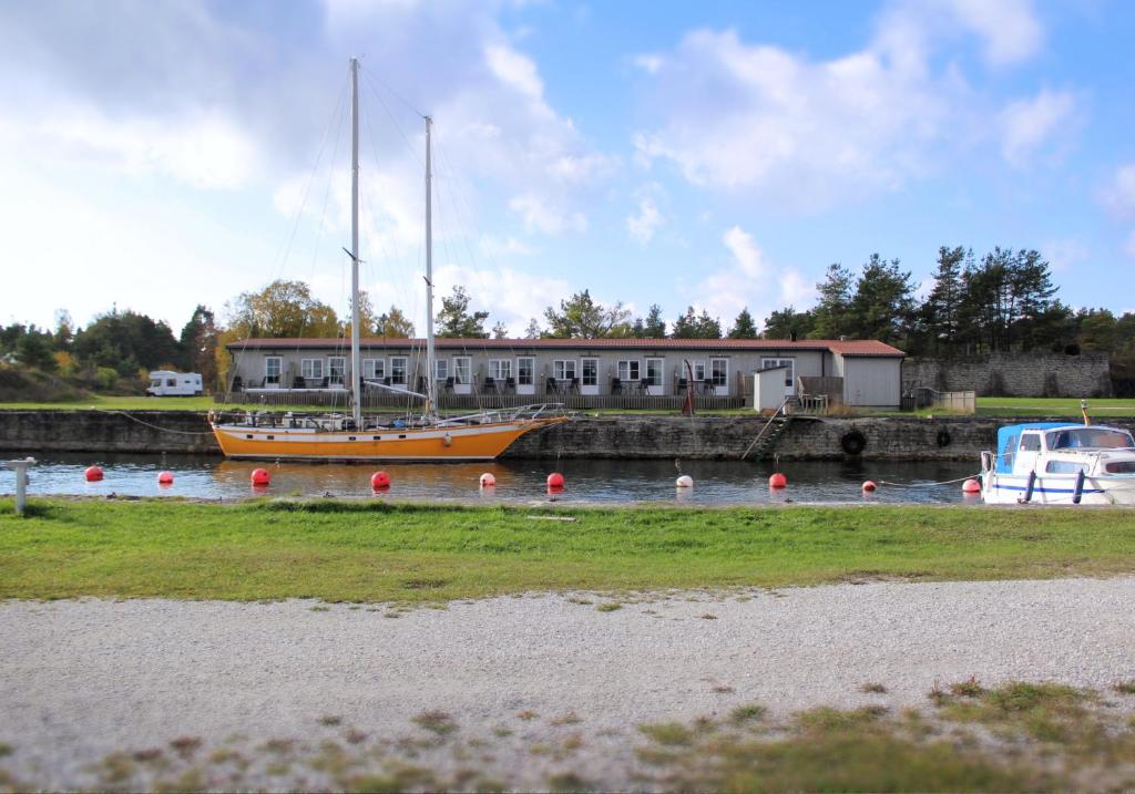 un barco sentado en el agua cerca de un edificio en Valleviken Hotell en Valleviken