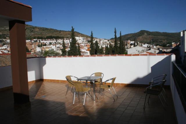 a patio with a table and chairs on a balcony at Las Casas de Nani in Beas de Segura