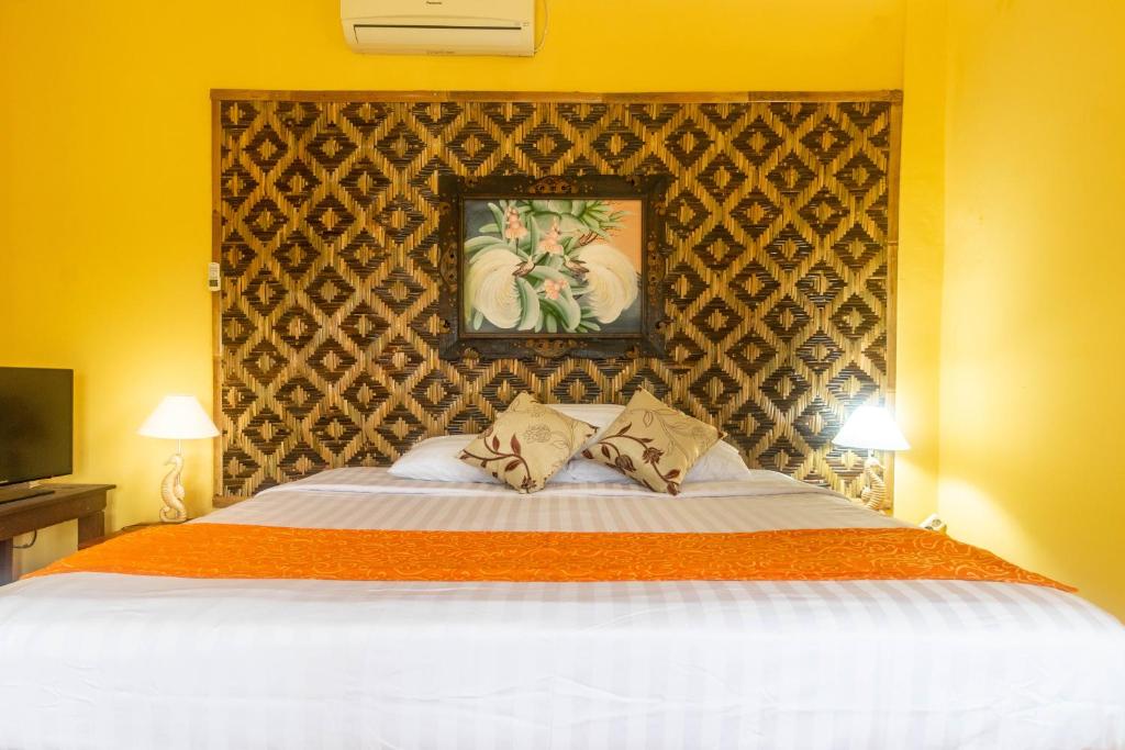 a bedroom with a large bed with two pillows at Rindik Guesthouse in Bangli