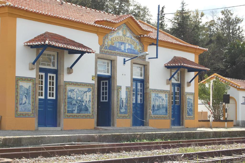 una estación de tren con puertas azules y mosaicos en Pensão Destino, en Castelo de Vide
