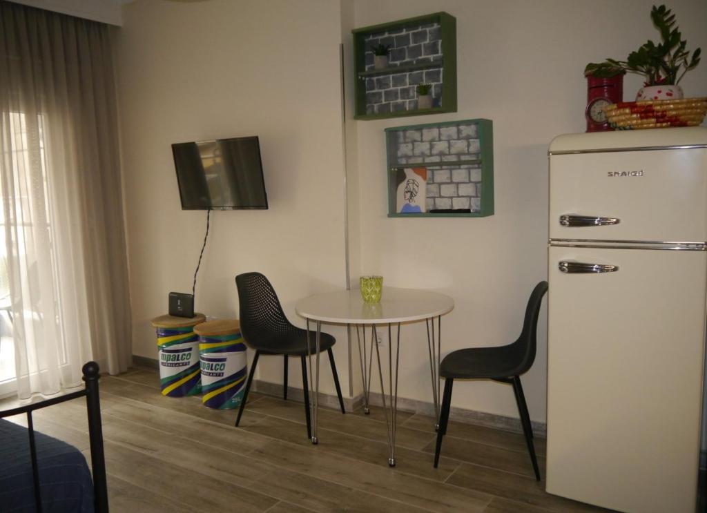 a kitchen with a table and chairs and a refrigerator at Cozy & Stylish Eastside Apt. in Thessaloniki