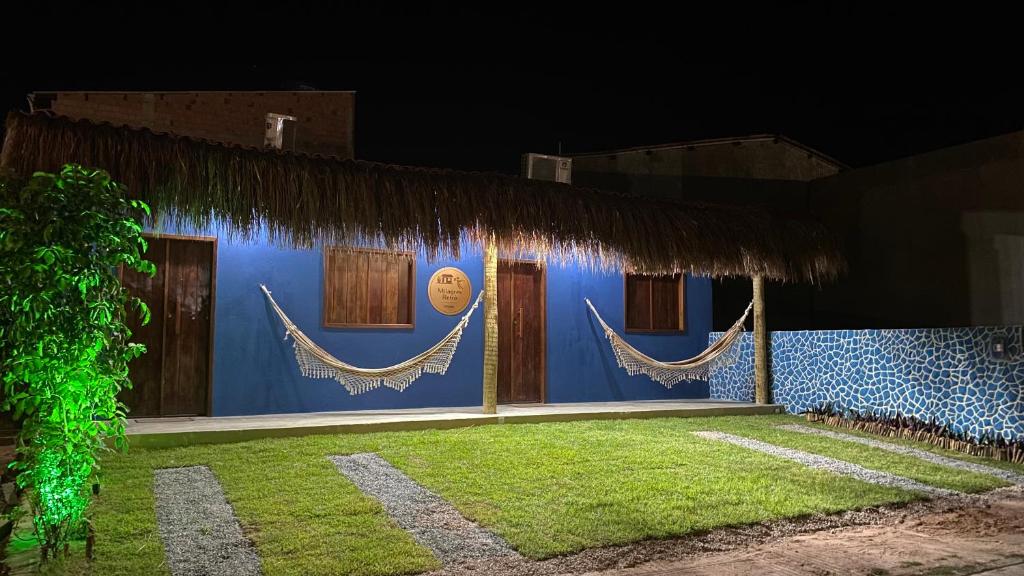 a blue building with hammocks on it at night at Milagres Retrô- Studio in São Miguel dos Milagres