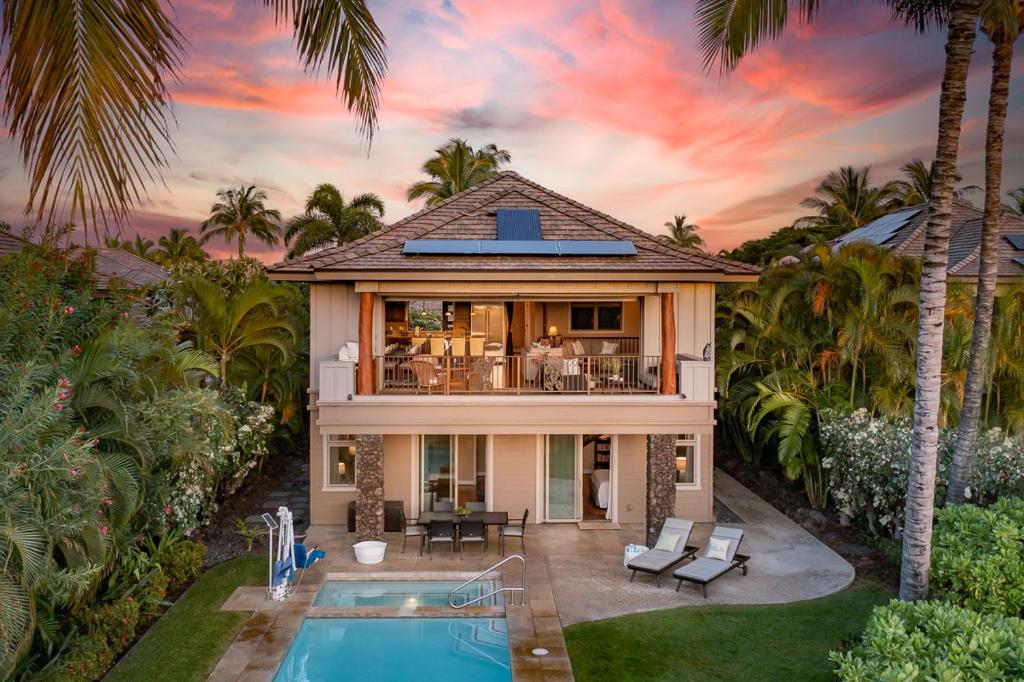 a villa with a swimming pool and a house at Mauna Lani KaMilo 217 in Waikoloa