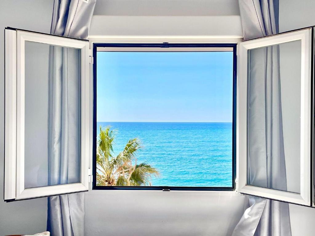 una ventana abierta con vistas al océano en Sea-view apartment in Adra with private terrace, en Adra