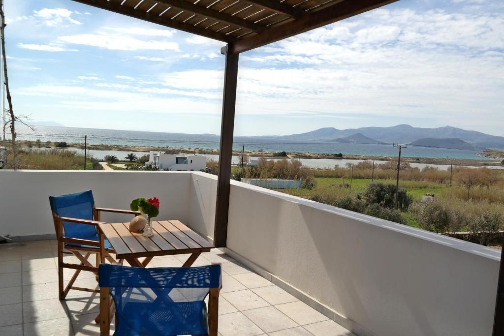 a table and chairs on a balcony with a view of the ocean at Dina's Diamond in Agios Prokopios