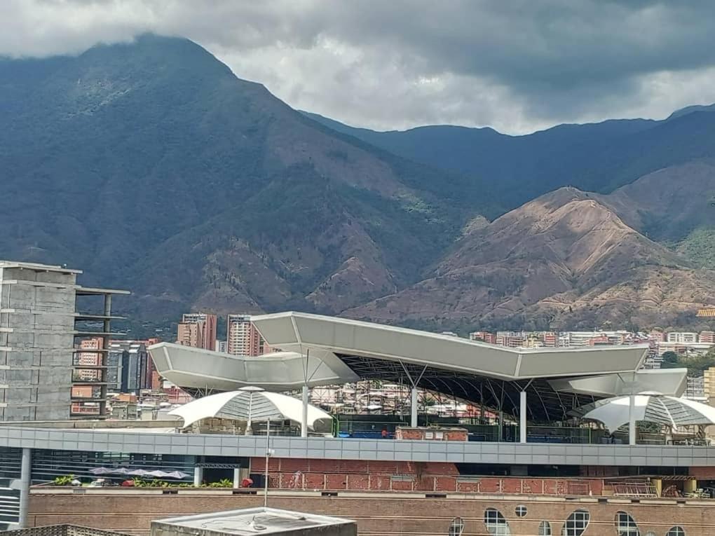vistas a un edificio con montañas en el fondo en CALIFORNIA SUITE en Caracas