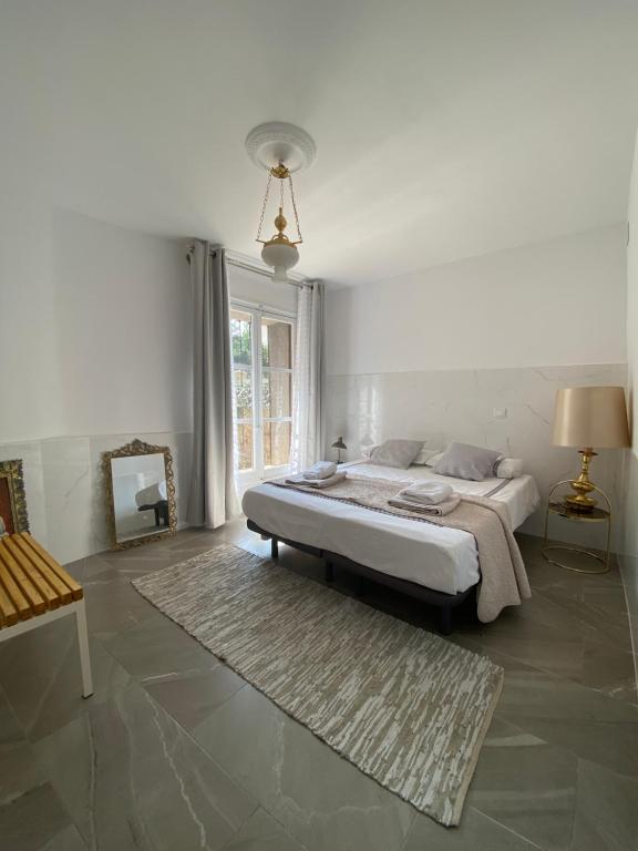 um quarto branco com uma cama e um tapete em Apartamentos Toledo Casa de los Aljibes em Toledo