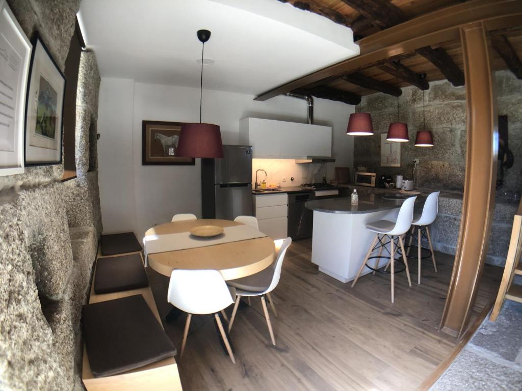 a kitchen and dining room with a table and chairs at Vila Cavalica in Bustelo