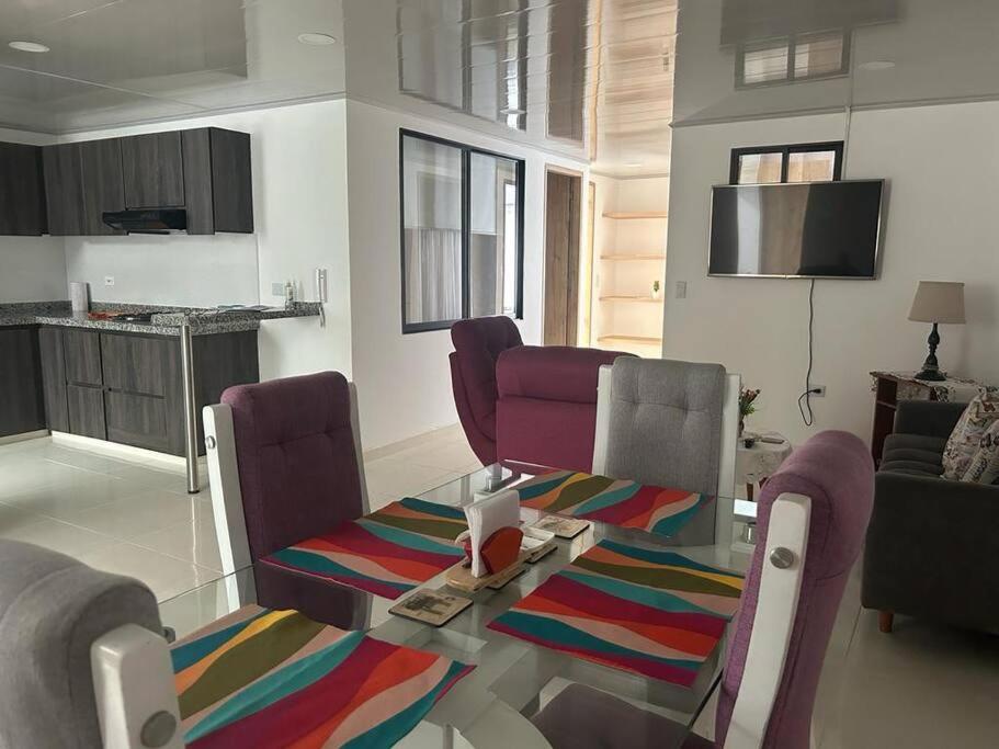 莫尼基拉的住宿－Magnifico apartamento，客厅配有玻璃桌和紫色椅子