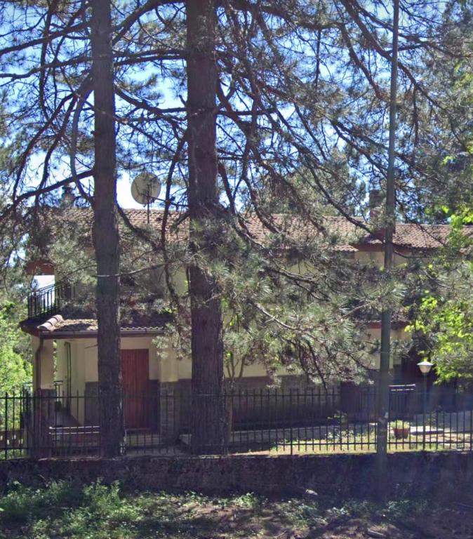 uma casa com uma cerca e árvores em frente em White’s House em Cutura