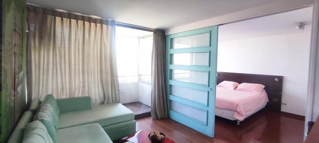 een woonkamer met een bank en een bed bij Apartment located in midtown in Santiago