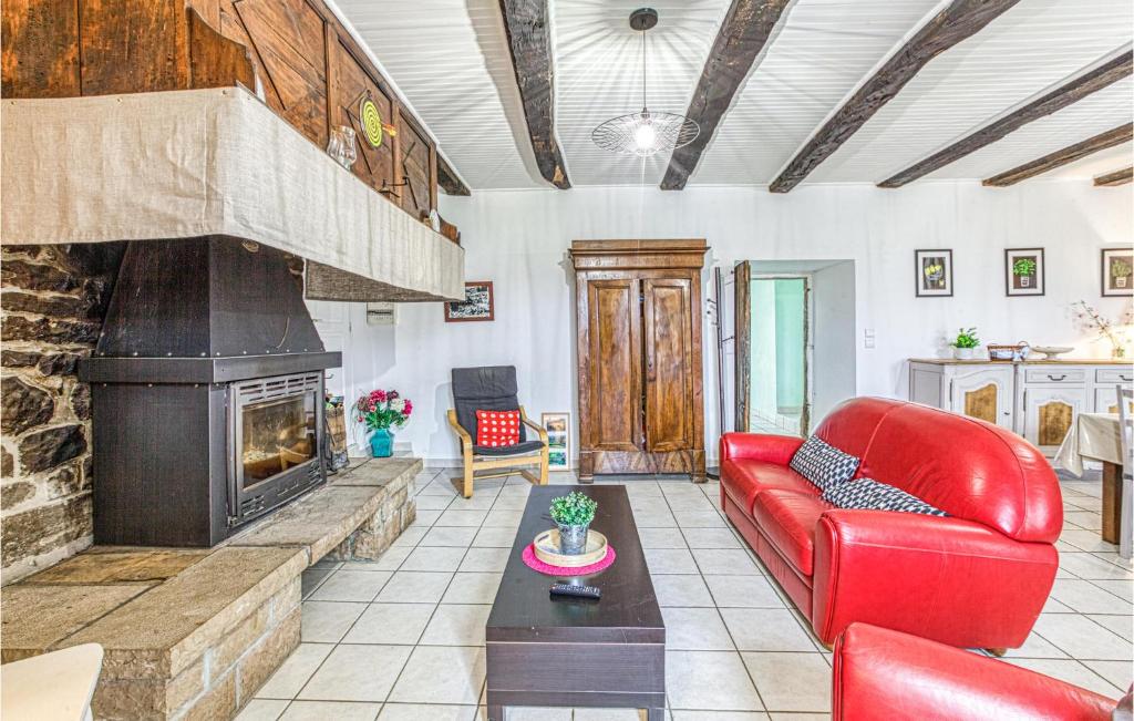ein Wohnzimmer mit einem roten Sofa und einem Kamin in der Unterkunft Stunning Home In Pierrefiche With Wifi in Pierrefiche