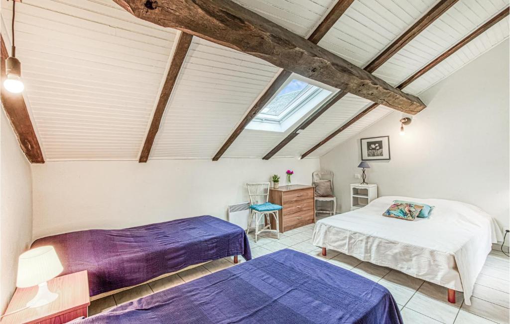 a attic bedroom with two beds and a window at Gorgeous Home In Pierrefiche With House A Panoramic View in Pierrefiche