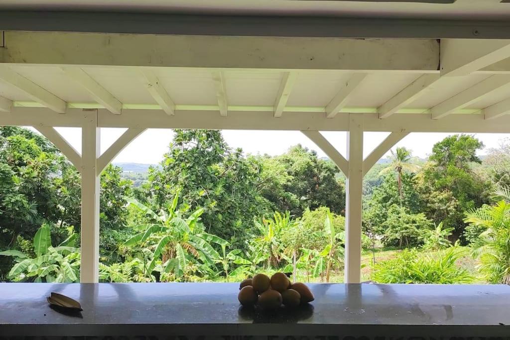 a porch with a view of a forest at Appartement neuf et tout confort sur la Trinité in La Trinité