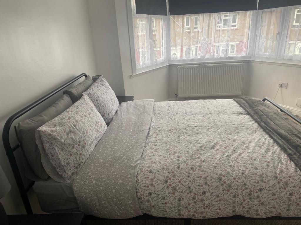 1 cama grande en un dormitorio con ventana en Hameway House- Stunning 4 bedroom house with a spacious kitchen en Londres