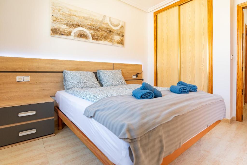 a bedroom with a bed with blue pillows on it at Casa Gris in Orihuela Costa