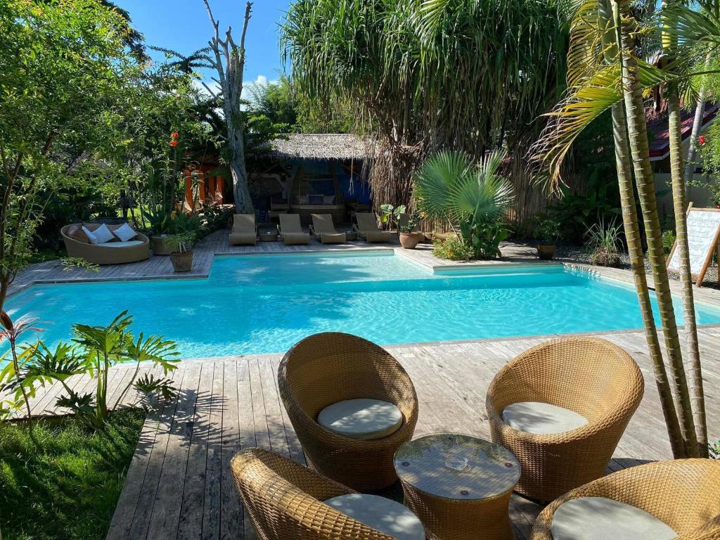 a swimming pool with chairs and a table next to it at Hibiscus Garden Inn in Puerto Princesa City