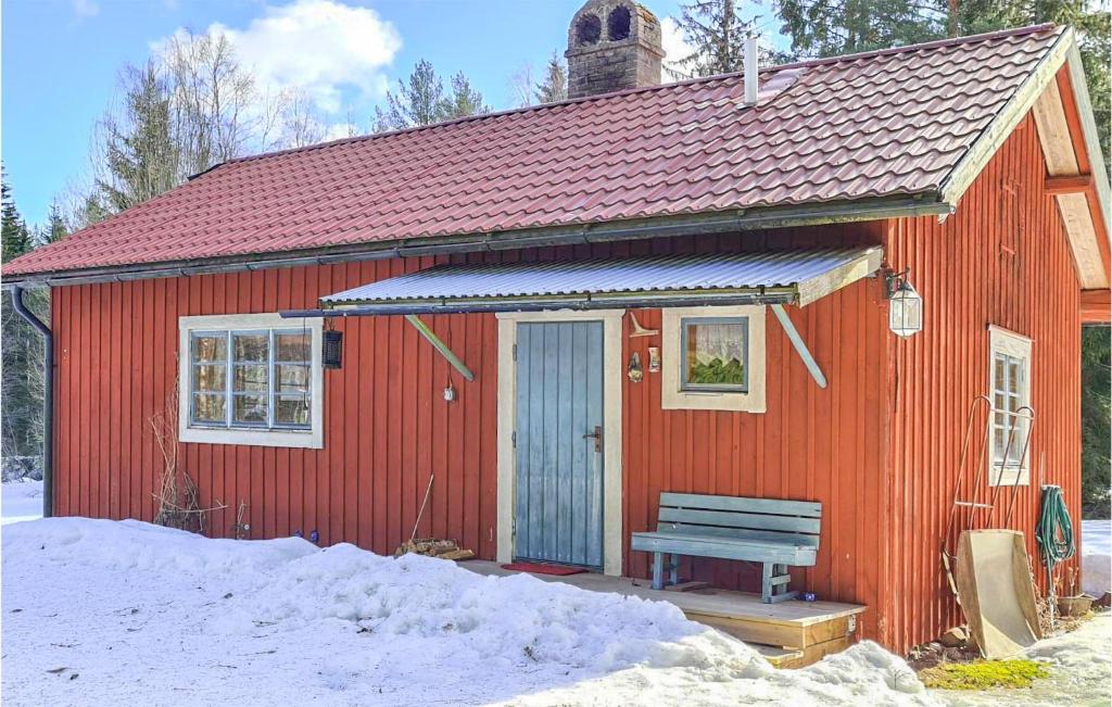 una casa roja con un banco delante en Gorgeous Home In Enviken With Kitchen, en Enviken