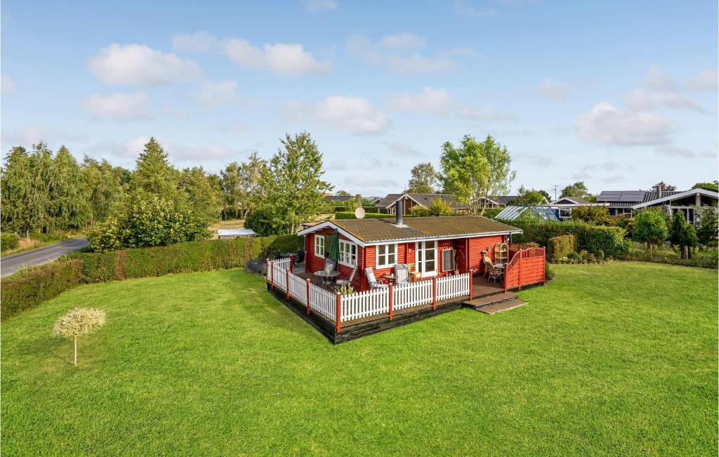 ein kleines rotes Haus auf einem grünen Rasen in der Unterkunft 1 Bedroom Awesome Home In Bog By in Bogø By