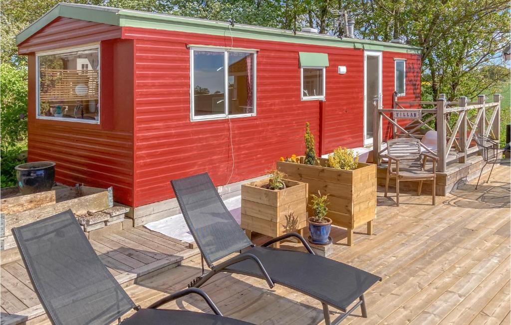 ein rotes winziges Haus mit Stühlen auf einer Terrasse in der Unterkunft Morup 7 in Morup