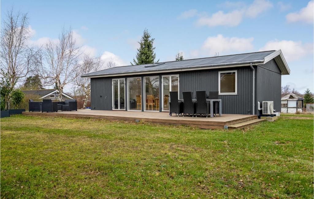 una pequeña casa gris con sillas en una terraza en Amazing Home In Prst With Kitchen, en Præstø