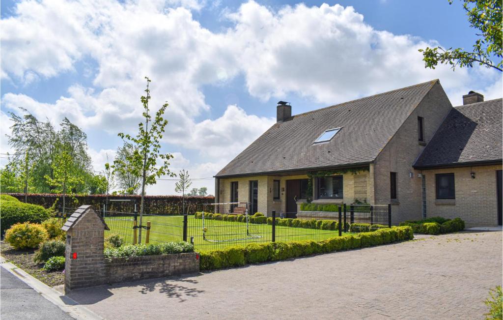 una casa con una valla delante de un patio en Nice Home In Langemark With House A Panoramic View, en Langemark