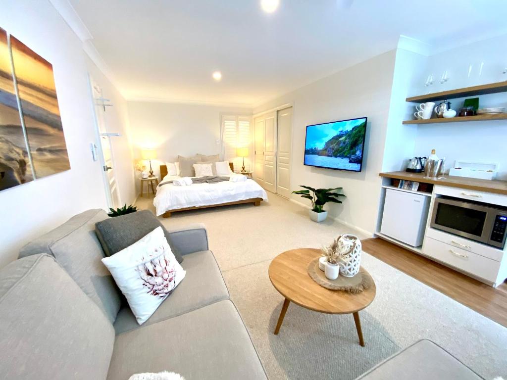 ein Wohnzimmer mit einem Sofa und einem Bett in der Unterkunft Casuarina Beach 2 bedroom retreat in Casuarina