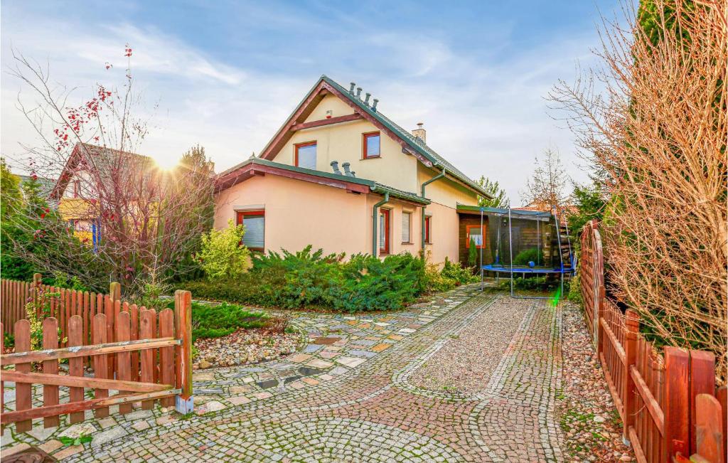 a house with a fence in front of it at Cozy Home In Sarbinowo With Wifi in Sarbinowo