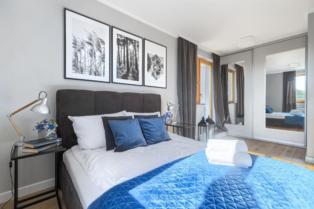 シュチェチンにあるEXCLUSIVE Polonia Apartmentsのベッドルーム1室(青い毛布付きのベッド1台付)