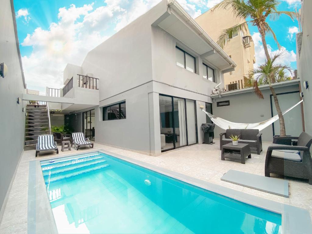 uma villa com uma piscina e uma casa em Boutique House - Private Pool & Rooftop on Best Location Barranquilla ! em Barranquilla