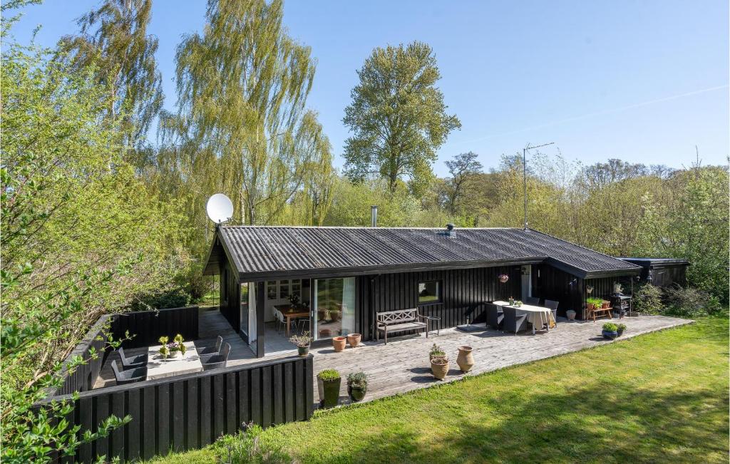 uma casa negra com um deque num jardim em Nice Home In Hornbk With Kitchen em Hornbæk