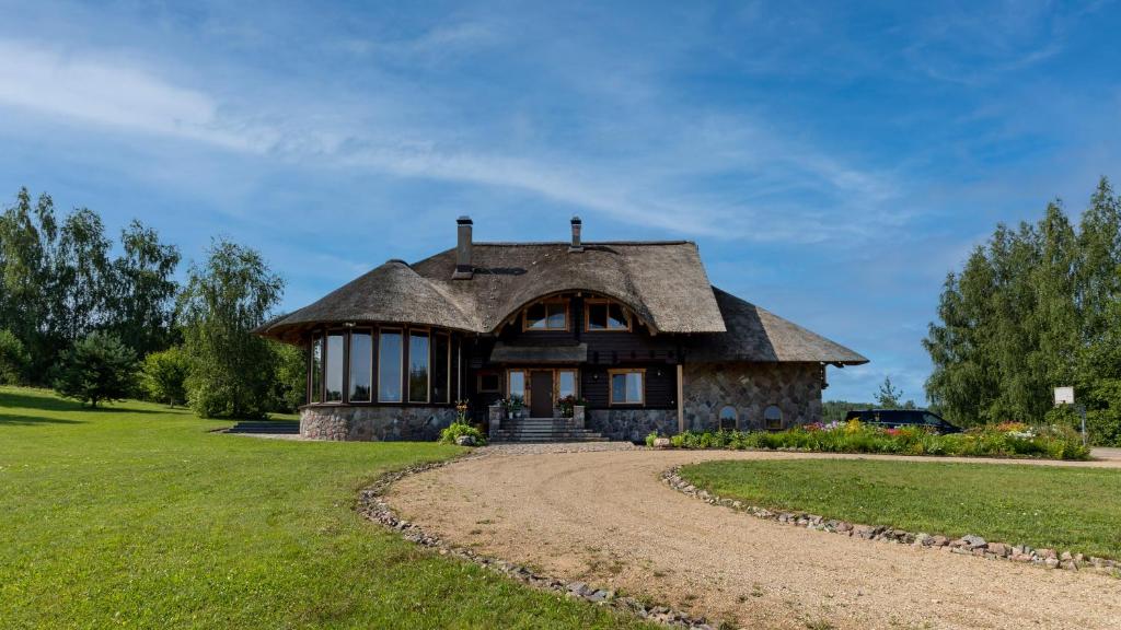 a large stone house with a gambrel roof at Viesu Sēta LOCU SALA in Krāslava