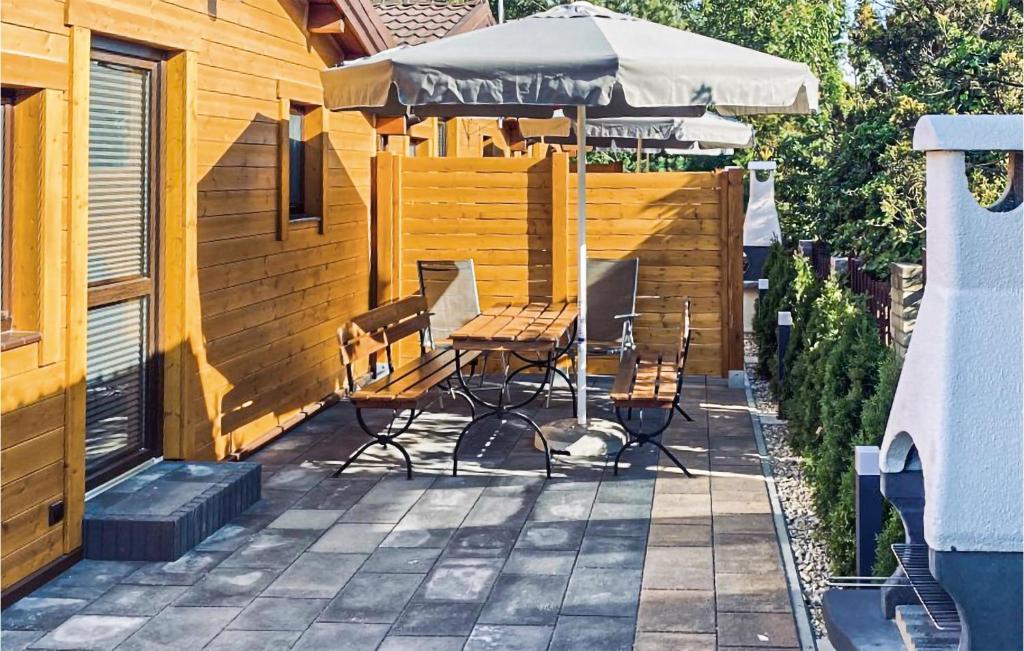 eine Terrasse mit einem Tisch, Stühlen und einem Sonnenschirm in der Unterkunft 2 Bedroom Stunning Home In Sianozety in Sianożęty