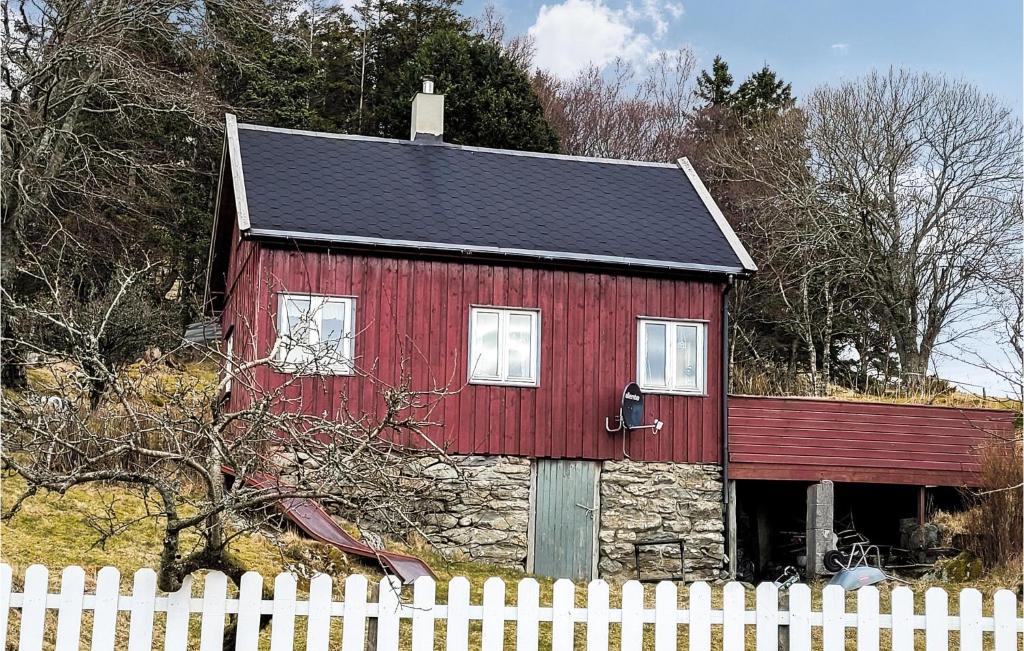 een rode schuur met een wit hek ervoor bij Stunning Home In Sveio With 4 Bedrooms in Sveio
