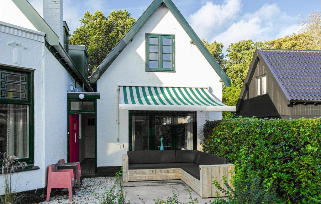 una casa blanca con un banco delante en Klein Maar Fijn, en Bergen